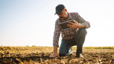 Agricultor tocando e realizando analise de solo