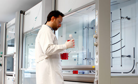 Homem operando capela de exaustão de gases