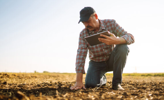 Agricultor tocando e realizando analise de solo
