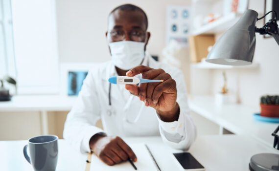 Médico experiente esta mostrando um dos termômetros digitais